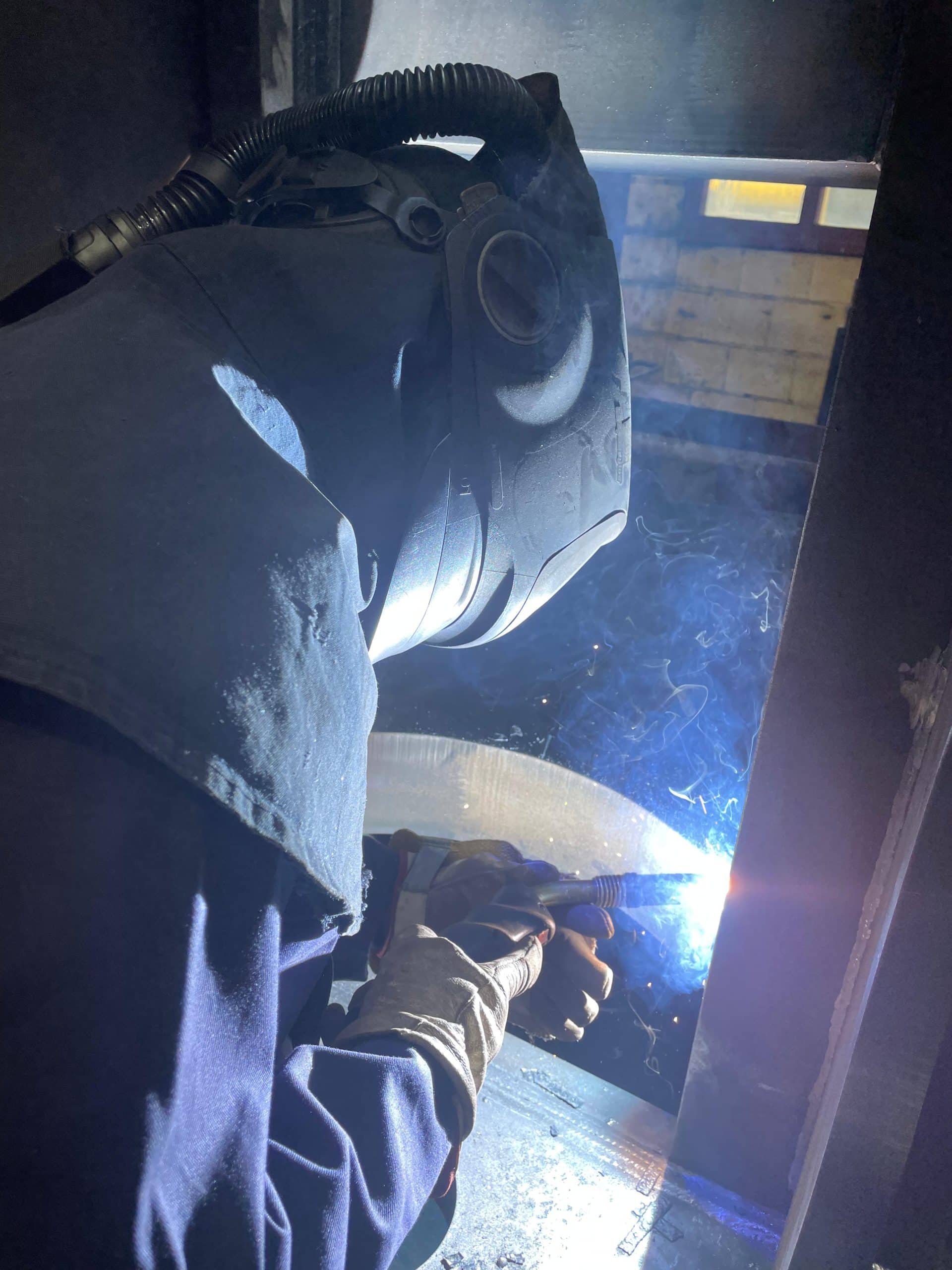 Foto van dichtbij van iemand die aan het lassen is.